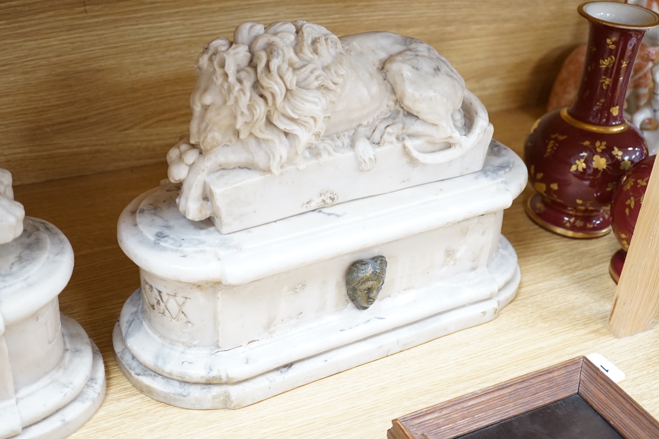 After the Antique. A pair of marble resin models of the Medici lions, each seated upon an oblong plinth, applied with bronze masks, inscribed LECXX, 41cm long, 15cm deep, 29cm high